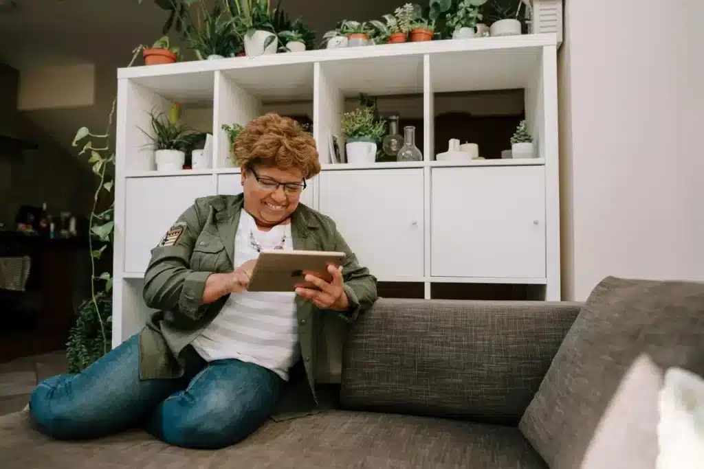 Senior using a tablet comfortably at home after tech help from Tek Solutions