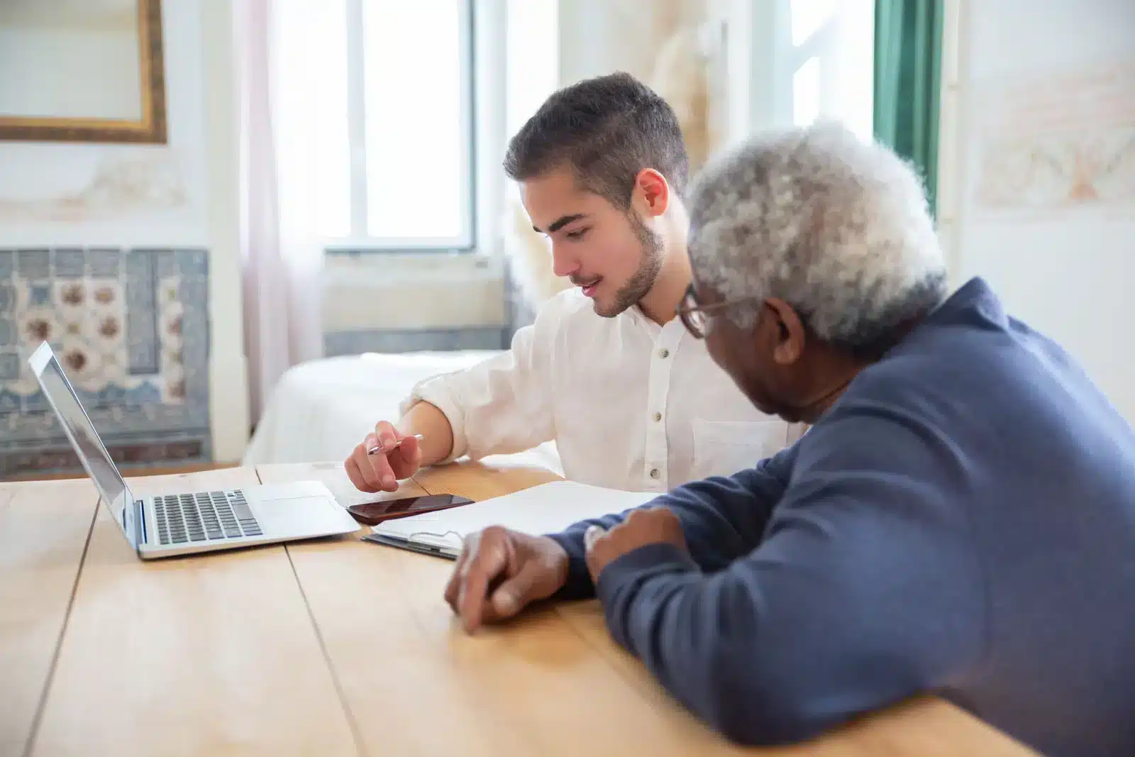 Tek Solutions technician helping a senior with his laptop at home in Chilliwack